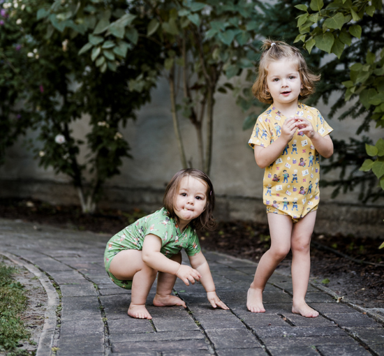 Zwei Kinder mit pauakids Wickelbodies auf einem Weg draußen