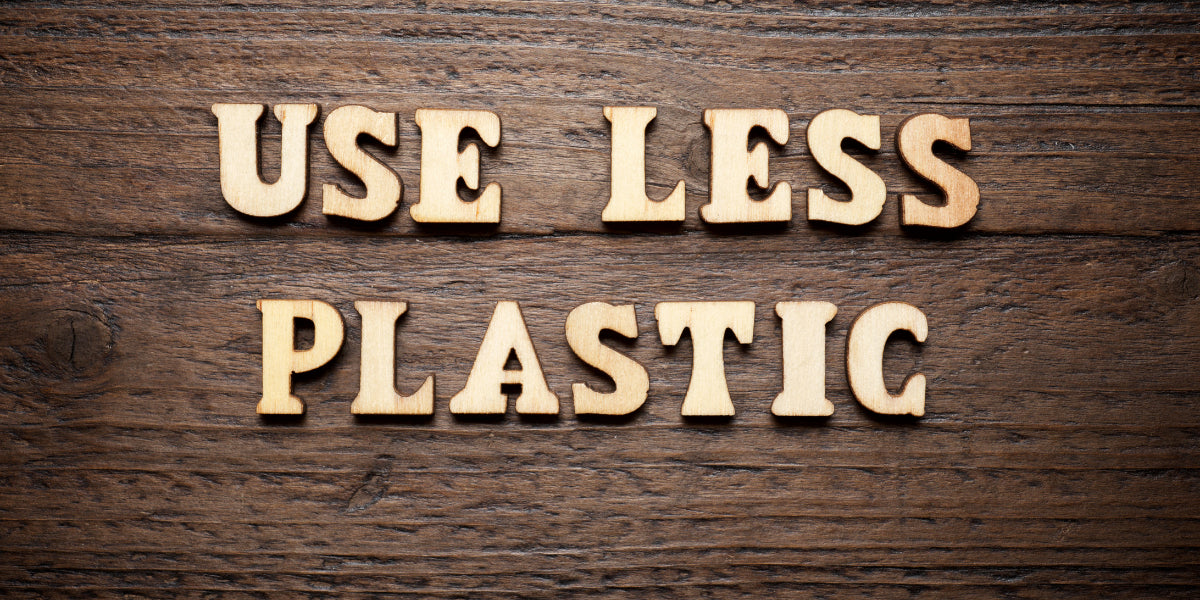 Schrift "Use less plastic" auf Holz