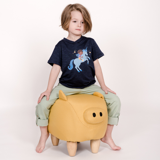 Kind sitzt auf Sitz-Schwein, mit Einhorn-Shirt von pauakids an
