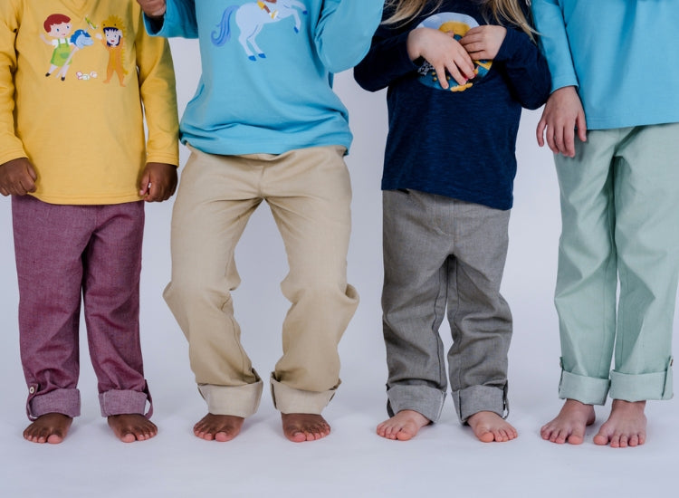 Vier Kinder, nur die Beine, mit pauaGrow Unisex Mitwachs-Hosen