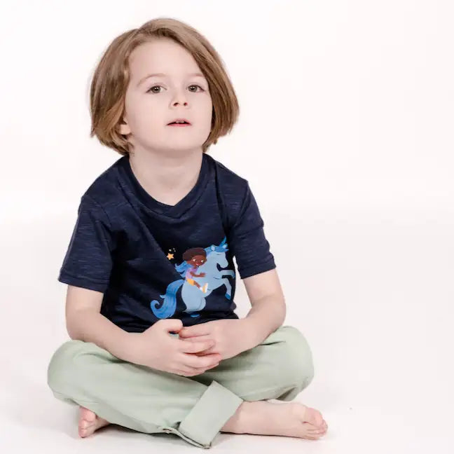 pauakids dunkelblaues Einhorn-Shirt getragen an Kind im Schneidersitz