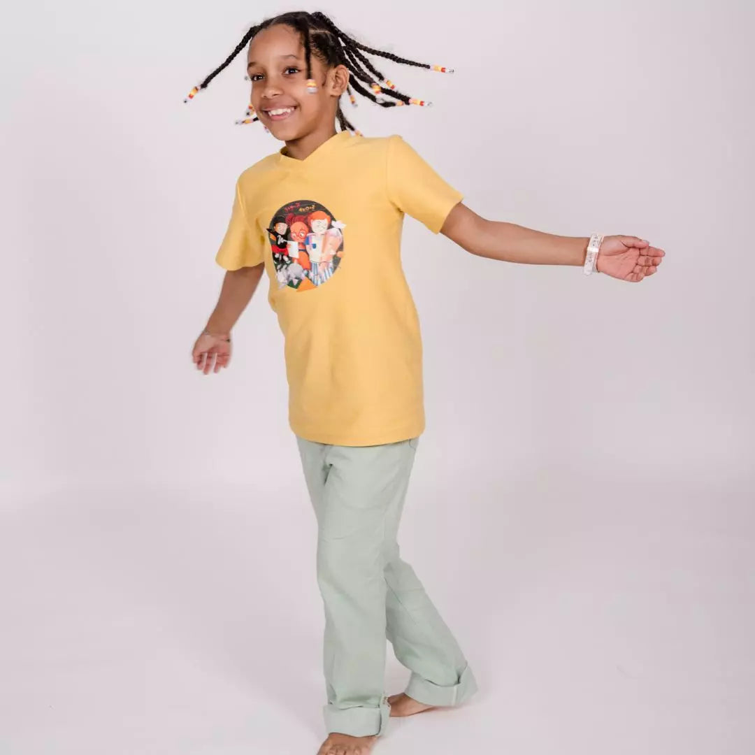 Schwarzes Kind trägt pauakids Mitwachsende Hose in grün und Shirt dazu und tanzt