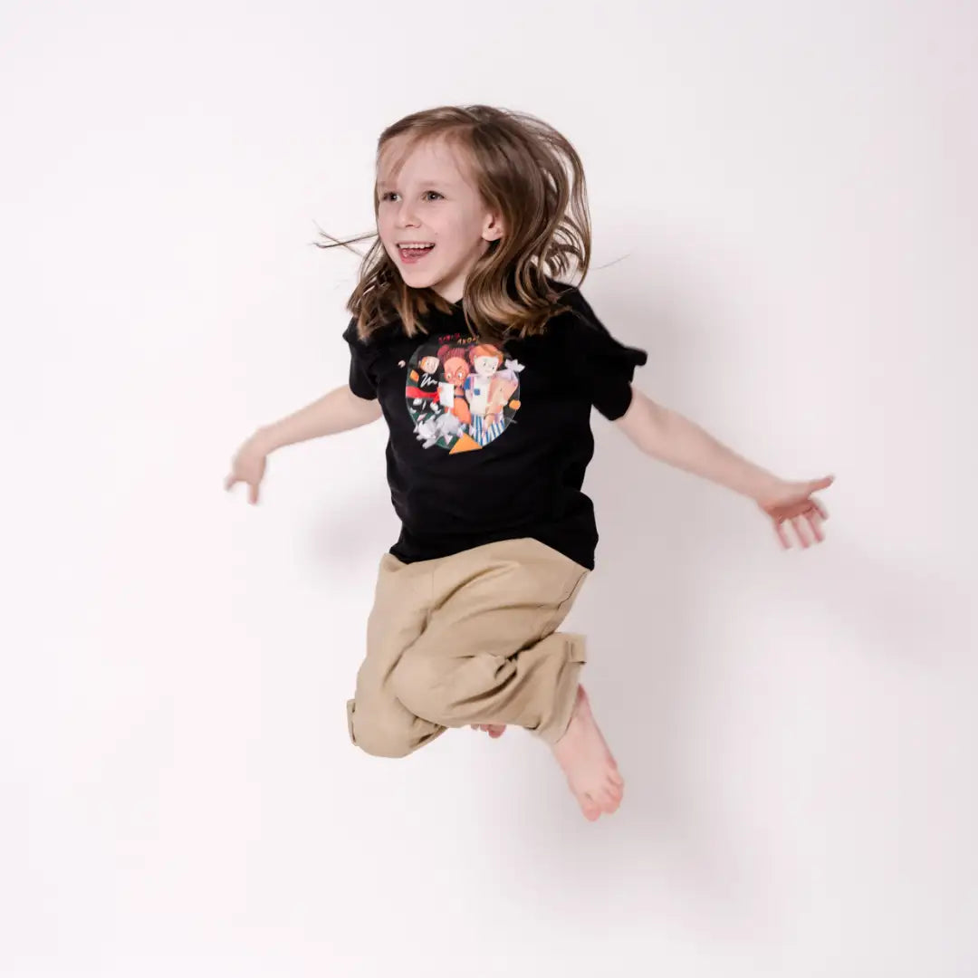 Kind sprint hoch in die Luft mit pauakids shirt Schulstart schwarz an