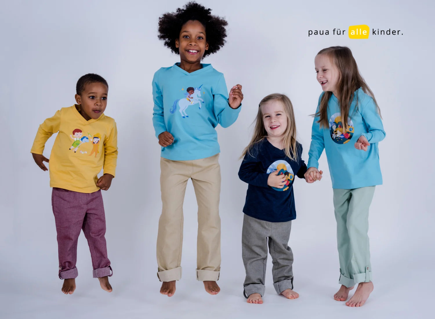 vier springende und lachende Kinder mit pauakids inklusive Kindermode