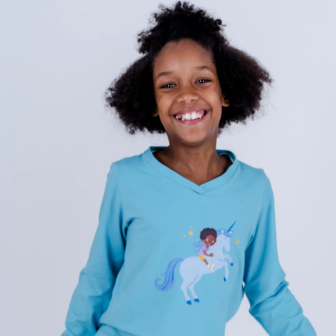 Einhörner für alle getragen von einem Kind, mit dunklen lockigen Haaren, das in die Kamera lacht