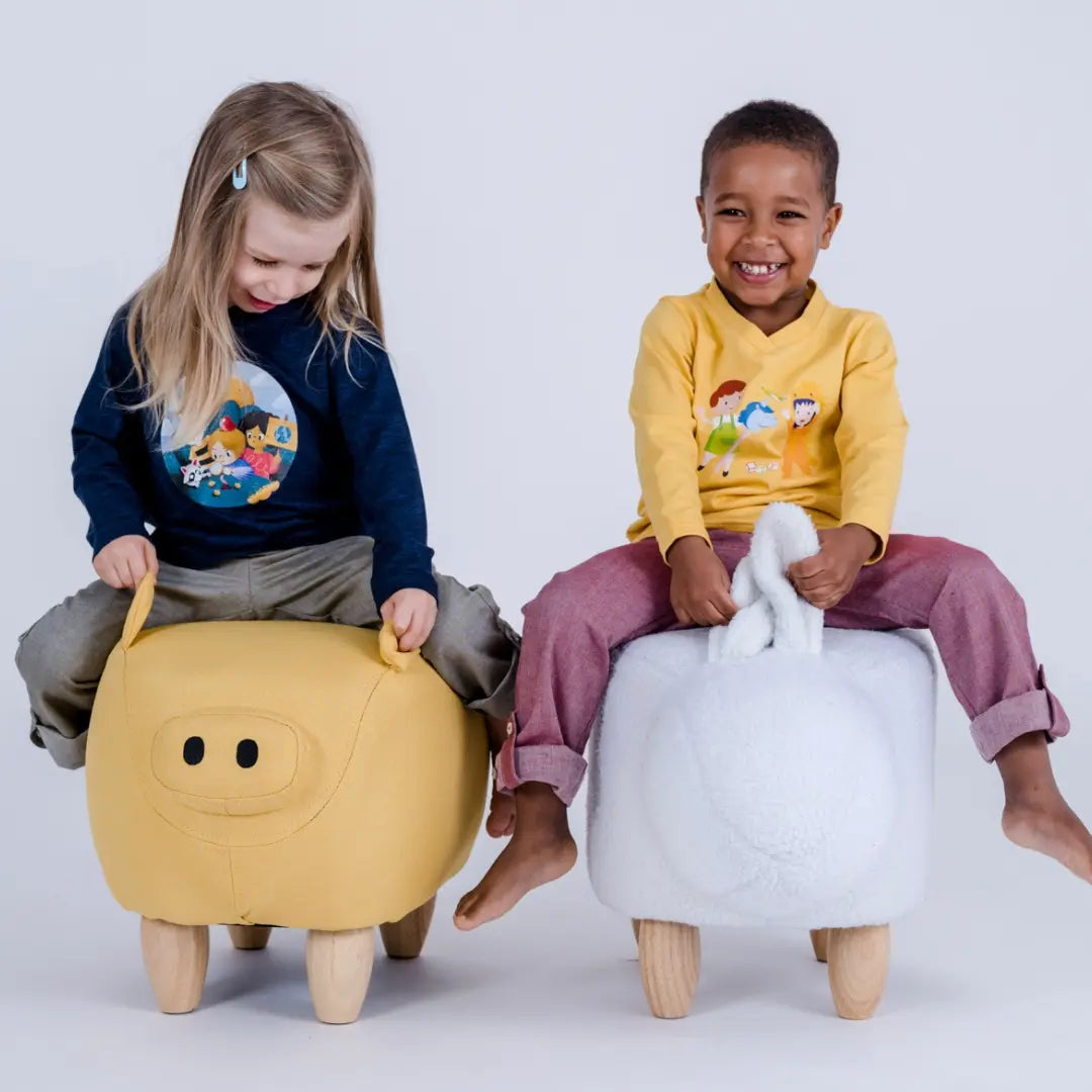 Zwei Kinder mit pauakids Verstecken und Green Generations Longsleeve auf Sitztieren haben Spaß