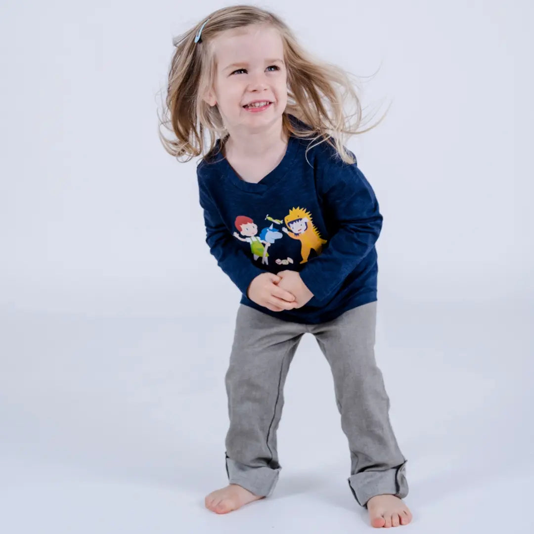 Kind mit langen Haaren mit Verstecken-Langarmshirt lachend, am Sprung