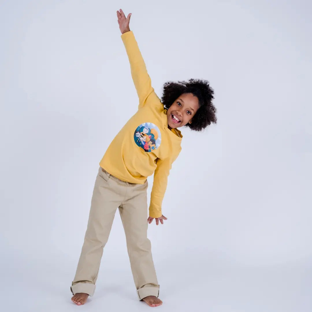 Kind lacht und macht Flieger-Bewegung mit pauakids Longsleeve in gelb